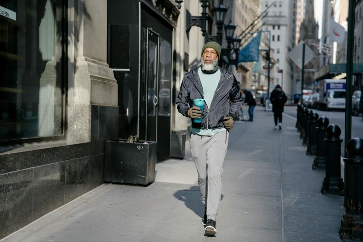 An older man walking down a city street.