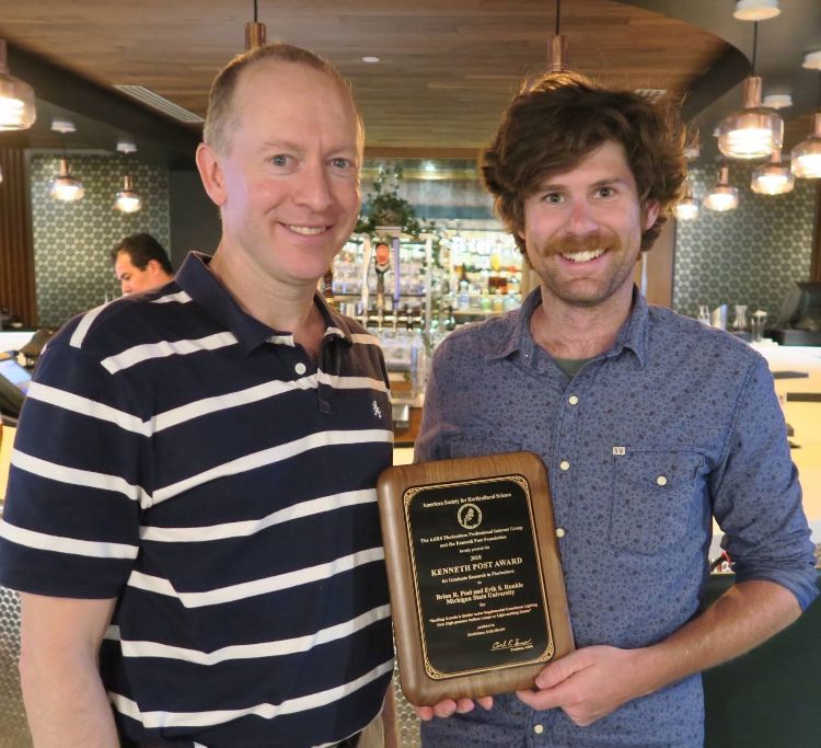 Runkle and Poel holding award plaque