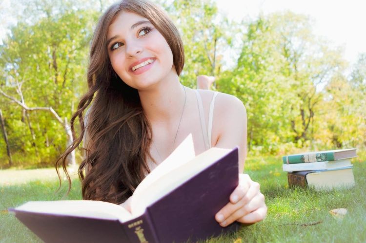 An image of Alexzandria Johns-Devries with a book.