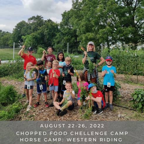 Campers holding up their carrots harvested from the Tollgate Edugarden.