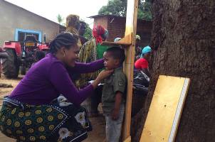 Theresia Jumbe collects height data from a child in Tanzania.