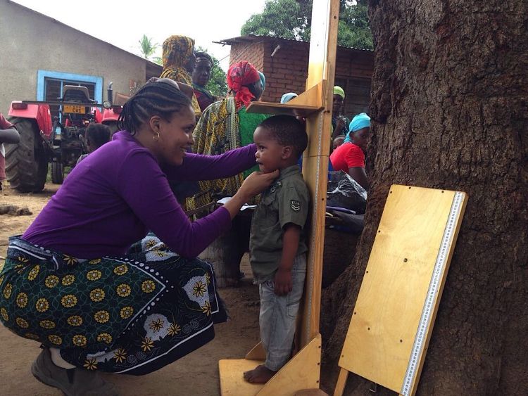 Theresia Jumbe collects height data from a child in Tanzania.