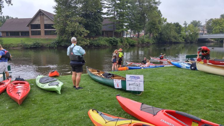 Kayak and canoe owners inspect their watercraft before entering the water.