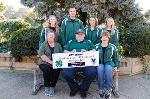 Group of 7 people that are a 4-H team and holding their award.