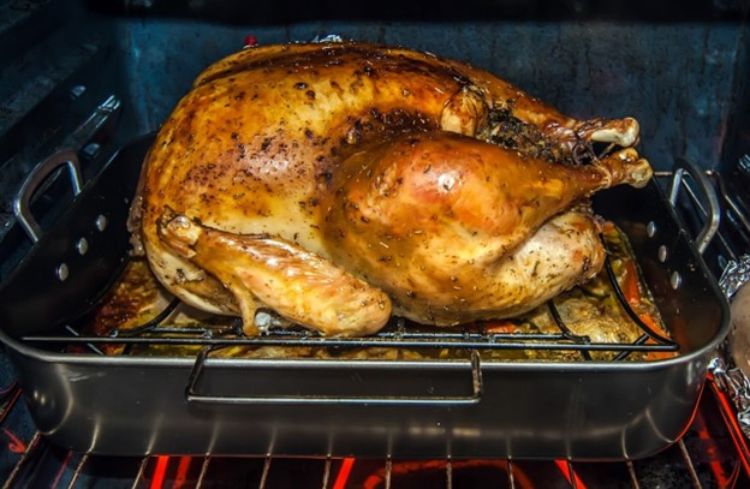 A turkey cooking in the oven.