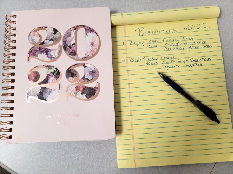 A 2022 planner that is next to a list of resolutions for 2022.