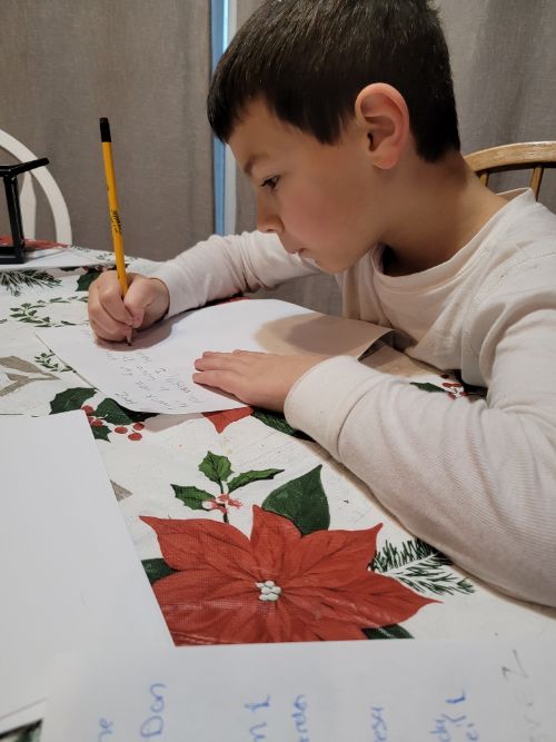 A young person writing a thank you note.