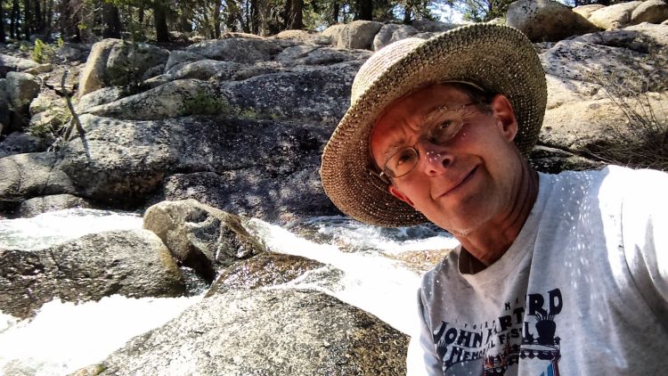 Photo of Robert Chipman in front of nature and rocks.