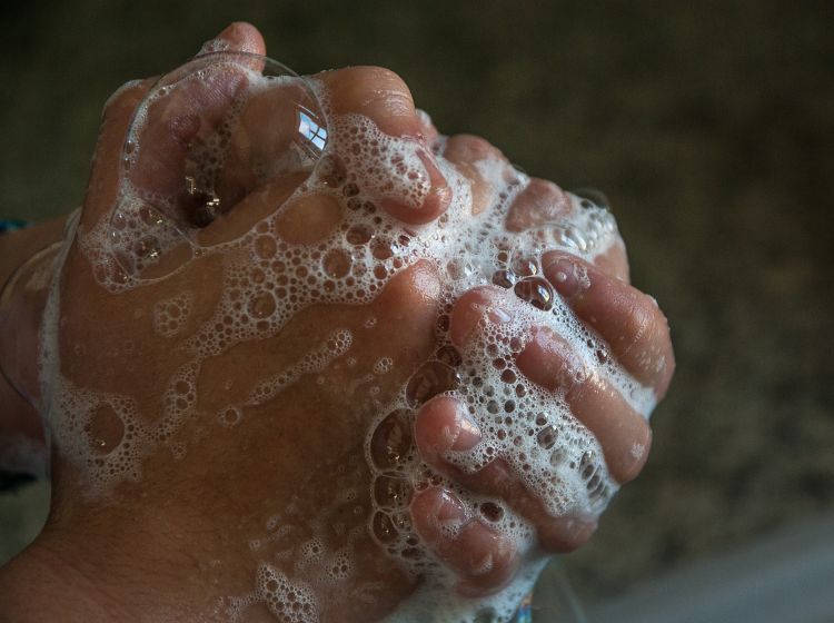 Clasped hands with soap suds.