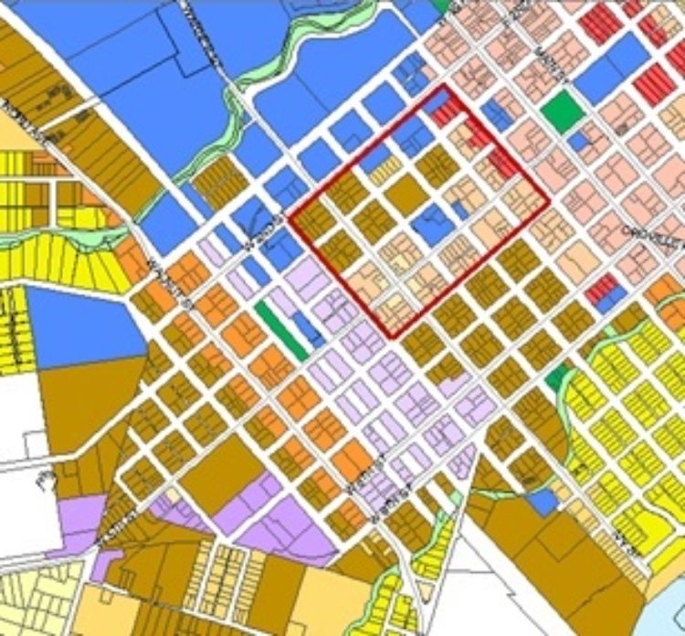 A zoning map with traditional underlying zoning districts shown with the different colors. The overlay district is illustrated with the red boundary, superimposed over a number of underlying zoning districts. MSU Extension Citizen Planner illustration.