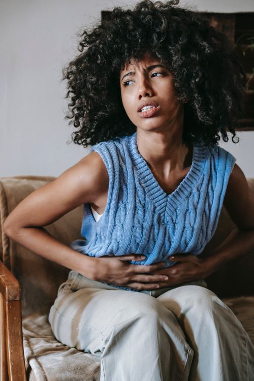 A woman clutching her stomach in pain.