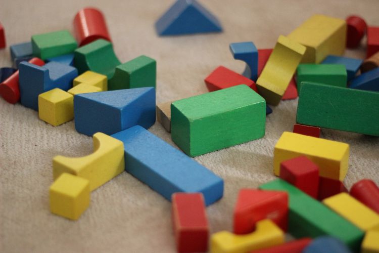 Help your child create a new play scheme by combining toys, for example add trucks and rocks to set of blocks. Photo credit: Pixabay.
