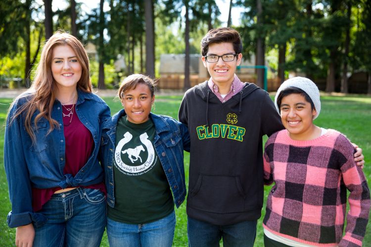 Four youth standing shoulder to shoulder.