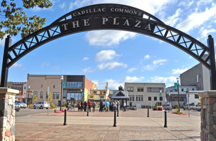 Photo of the gated entryway for Cadillac Commons in downtown Cadillac, showing the alley and back side of buildings impacted by this redevelopment project.