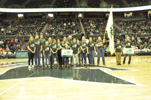 Group of Michigan 4-H'ers wearing 4-H apparel standing in the center of the Spartan's Breslin Center.