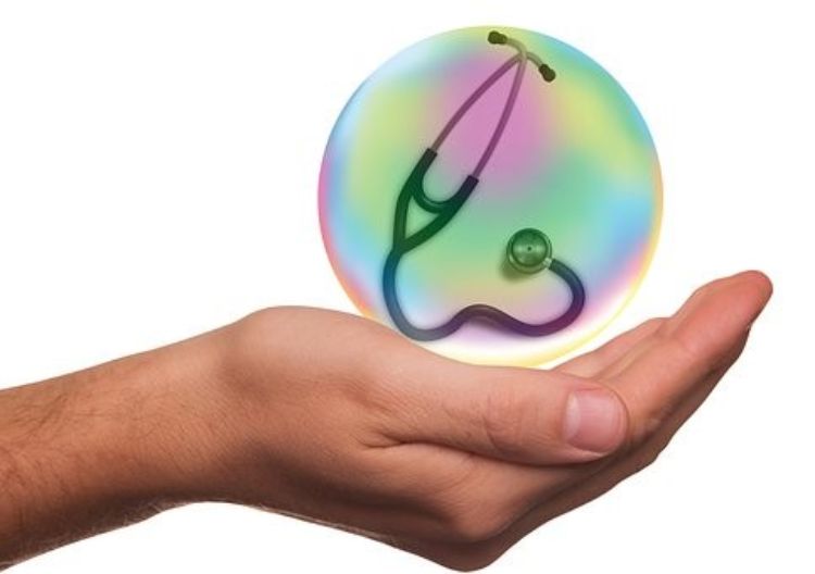 Human hand holding a ball containing a stethoscope