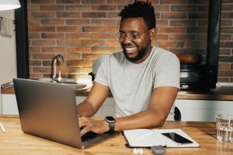 Individual working on a laptop at home.