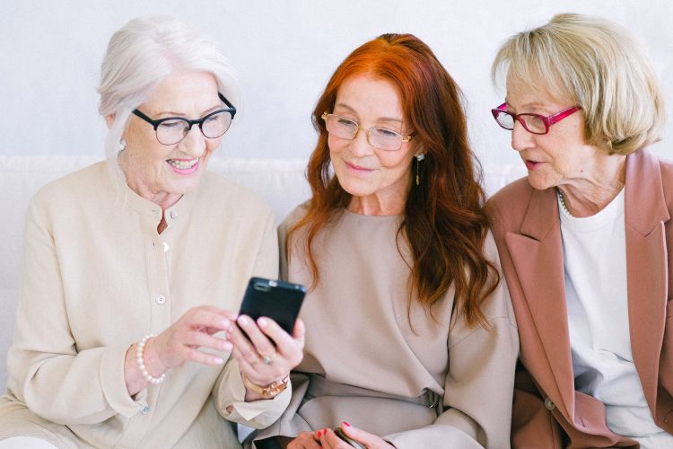 Three older women watching a video on a phone.
