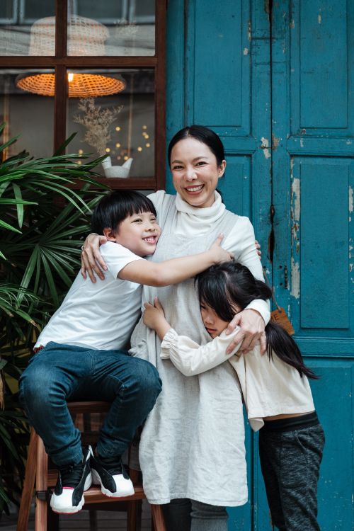 Woman smiling and hugging two kids