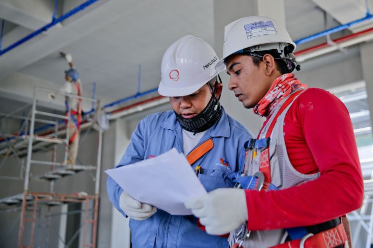 Two men in hard hats talking to each other