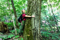 Forester alumni magazine summer 2019 edition Impact front cover - student Alex Love hugging a large tree