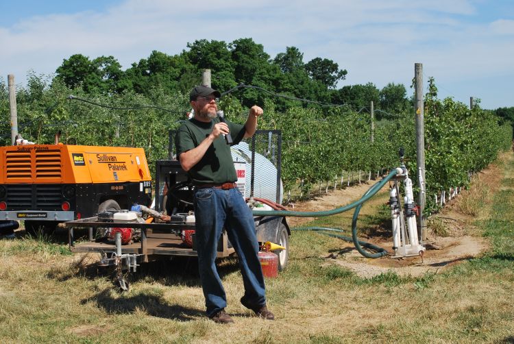 MSU researcher Matthew Grieshop demonstrates a solid set canopy delivery system.