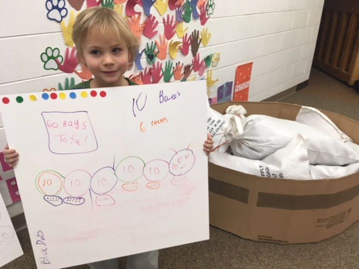 An Alcona County first grader shows the math they did to calculate the soil they would need to plant a raised pollinator garden