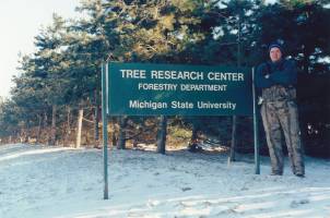 Alan Proctor standing in front of Tree Research Center sign