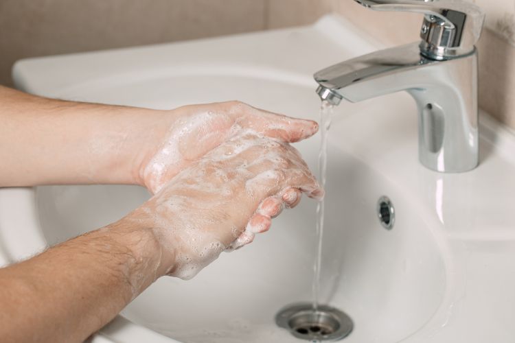 Closeup of a person's hands lathered up as they are washing them.