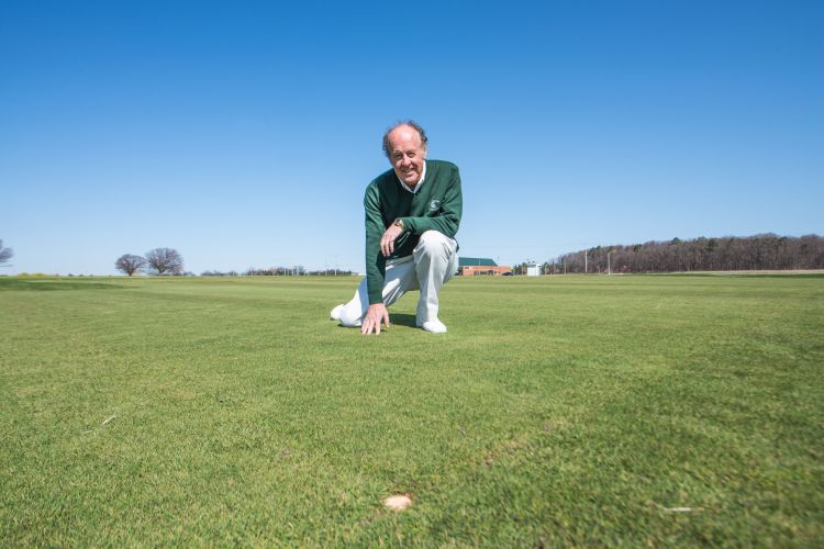 Joseph Vargas poses on a plot of Flagstick turfgrass.