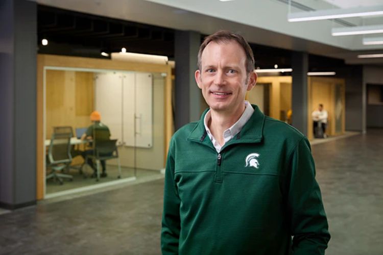 Matthew Daum smiling, wearing a green MSU pullover CANR