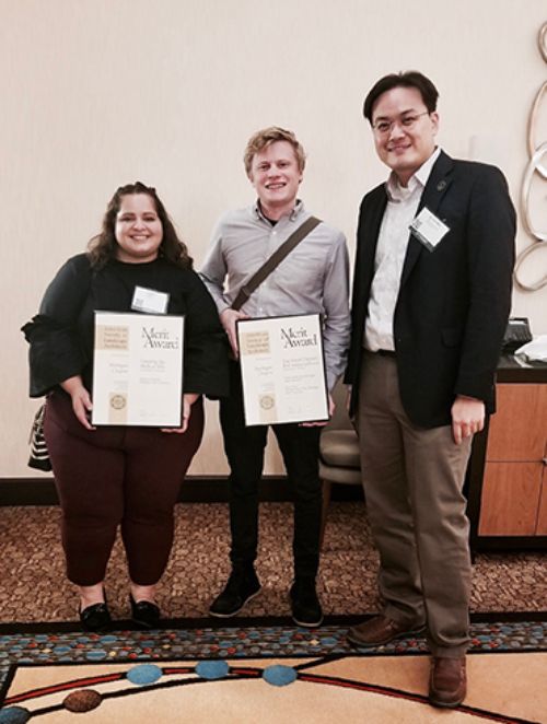 Image of MiASLA award winners standing with professor Jun-Hyun Kim holding award certificates.
