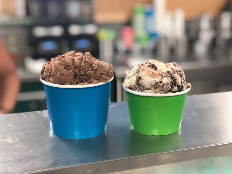 Two cups of ice cream with different flavors.