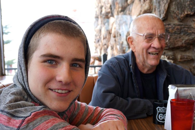 Youth and senior man sitting together