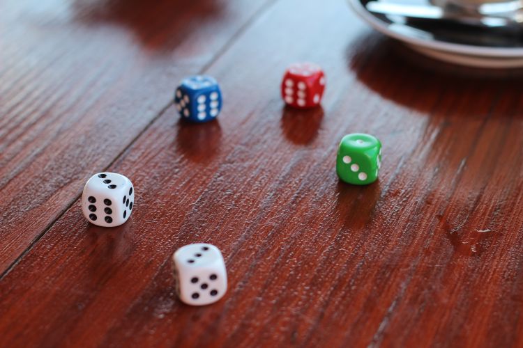 5 different colored dice on table.