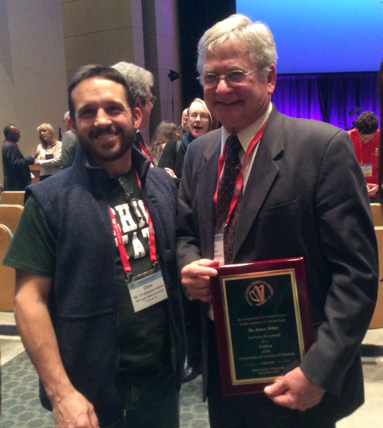 Jim Miller poses with his award with Chris Adams, graduate student and collaborator.