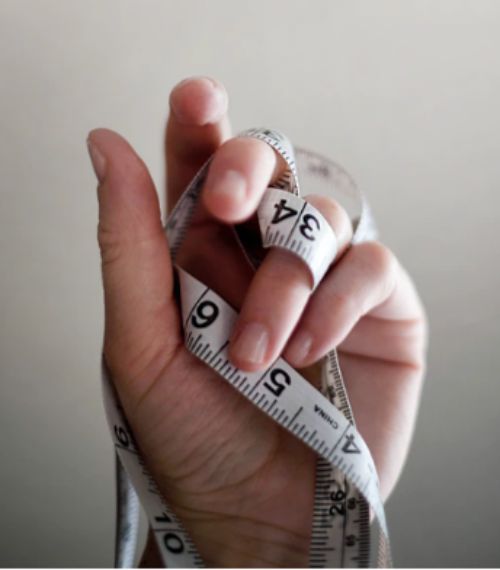 Hand holding measuring tape