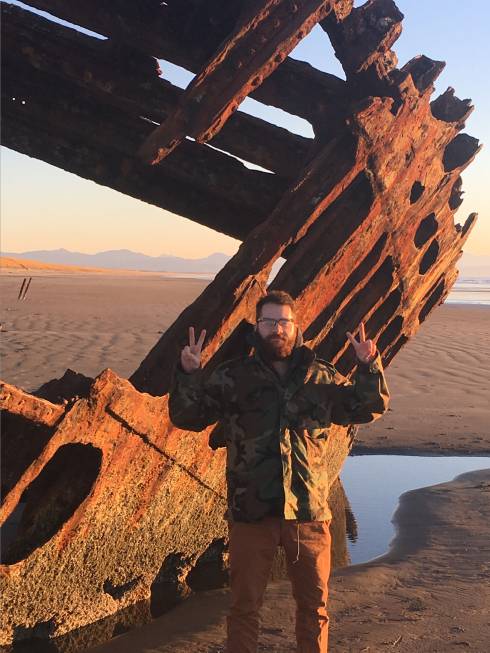 Huron Pines AmeriCorps member Adam Ziani stands near a shipwreck on the Pacific Coast. He hopes to translate his Pacific Coast experiences to help inspire Great Lakes explorations among youth in Northeast Michigan.