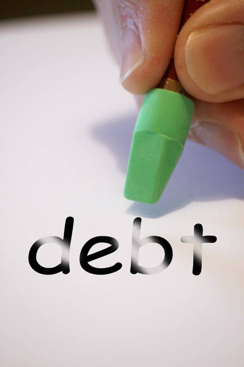 The word debt on a piece of paper being erased