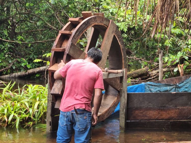A man from the Alto Mentae community checks an experimental water wheel that was built by the community. By Igor Cavallini Johansen