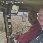 Jeff and Lee sit in tractor cab.