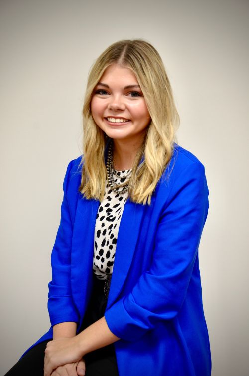 Caucasian teen girl with blond hair and a blue blazer.