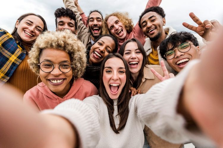 A group of people smiling and taking a selfie.