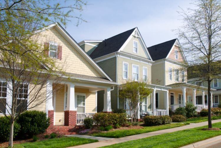 Photo depicts three multi-story condominiums with a sidewalk joining the front walkways of each.