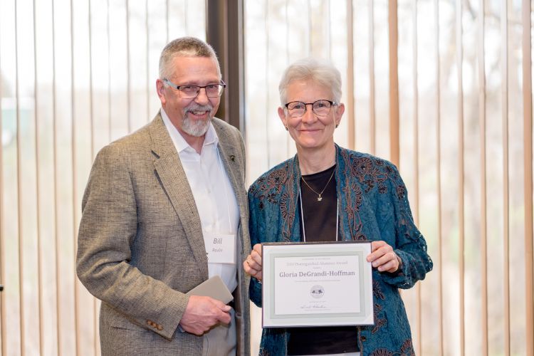 Gloria DeGrandi-Hoffman received the Distinguished Alumnus award from Bill Ravlin.