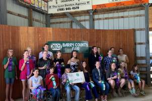 Non-livestock participants hold up their ribbons in front of the 2021 Barry County Fair sign.