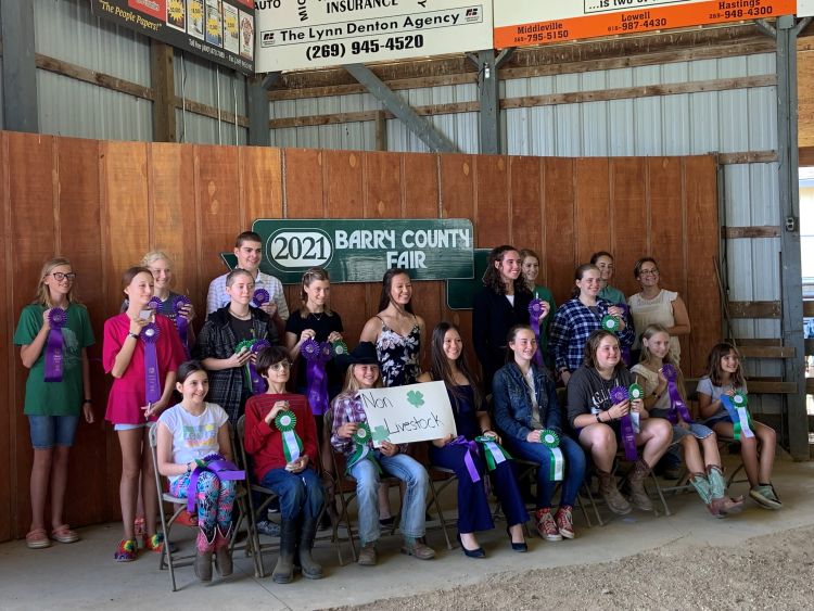 Non-livestock participants hold up their ribbons in front of the 2021 Barry County Fair sign.