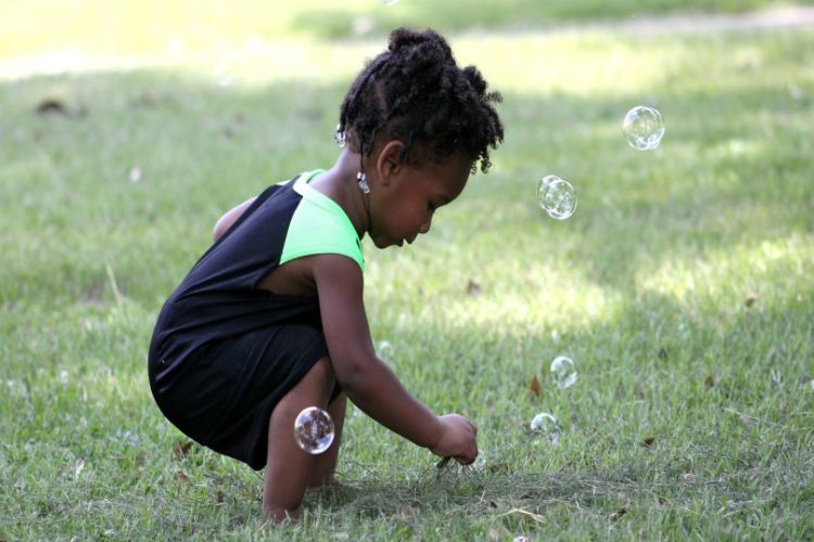 Toddler blows bubbles.