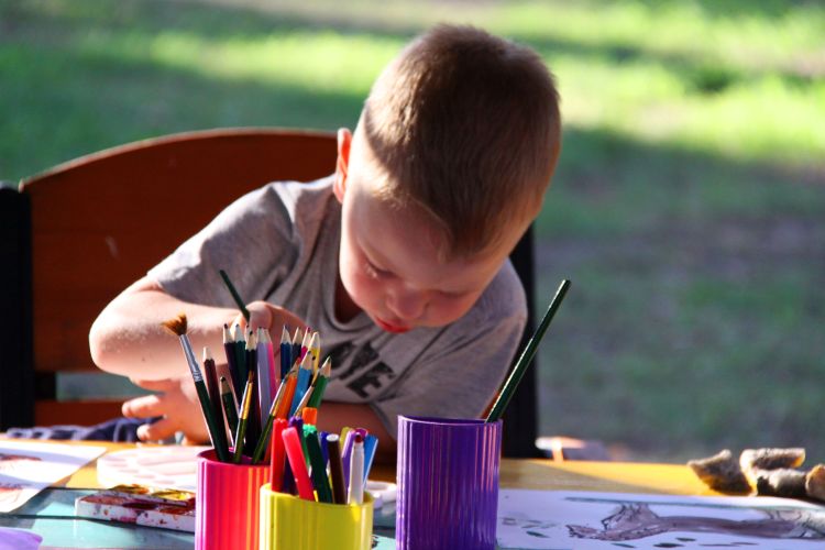 Ask open-ended questions about artwork to encourage children to talk about what they are doing.