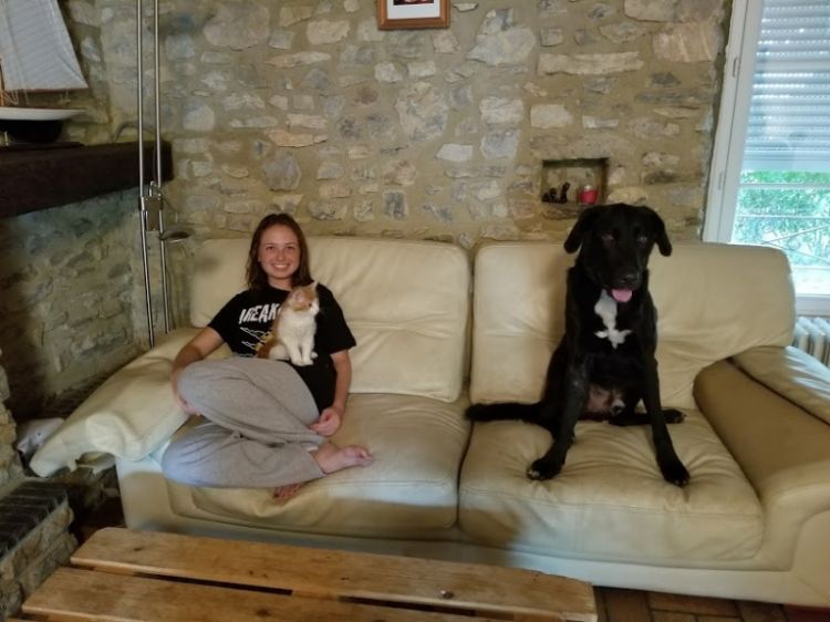 Emily with a cat and dog on a couch.